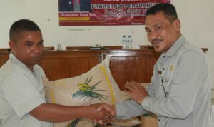 Anggota DPRD SBD, Octavianus Dapa Talu, saat menyerahkan bibit padi secara simbolis kepada Ketua Kelompok Tani Lede Moripa, Agustinus Malo (AH/Suarajarmas.id)