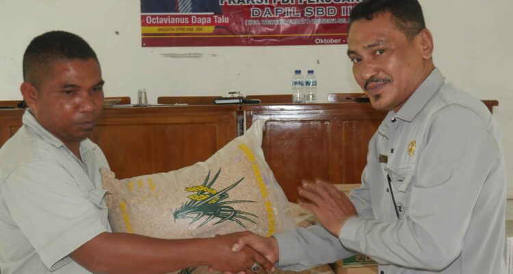 Anggota DPRD SBD, Octavianus Dapa Talu, saat menyerahkan bibit padi secara simbolis kepada Ketua Kelompok Tani Lede Moripa, Agustinus Malo (AH/Suarajarmas.id)