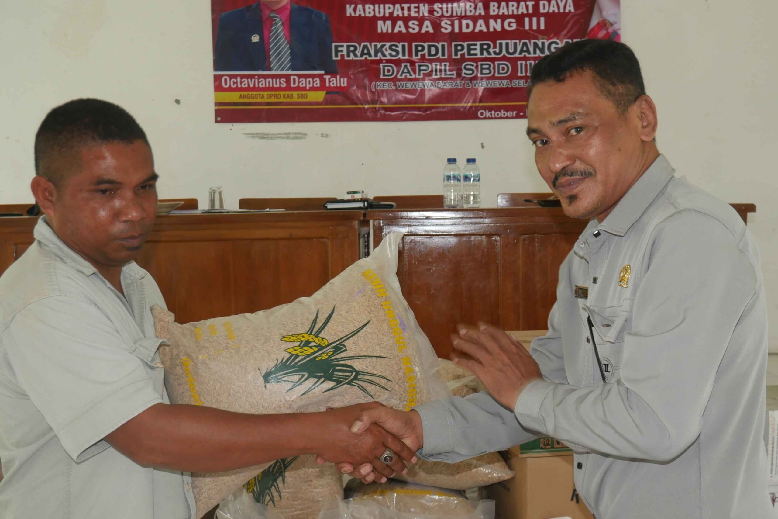 Anggota DPRD SBD, Octavianus Dapa Talu, saat menyerahkan bibit padi secara simbolis kepada Ketua Kelompok Tani Lede Moripa, Agustinus Malo (AH/Suarajarmas.id)