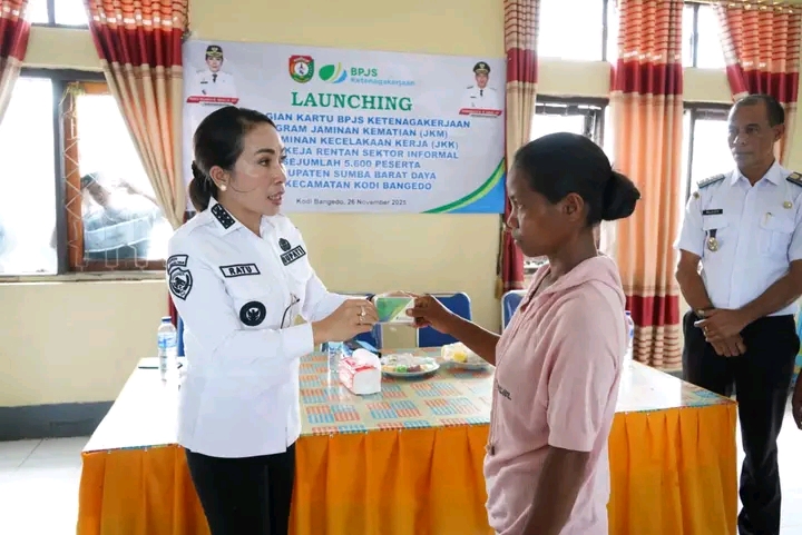Bupati SBD, Ratu Ngadu Bonu Wulla, secara simbolis menyerahkan kartu kepesertaan BPJS Ketenagakerjaan salah satu peserta di Kantor Kecamatan Kodi Bangedo (Suarajarmas.id)